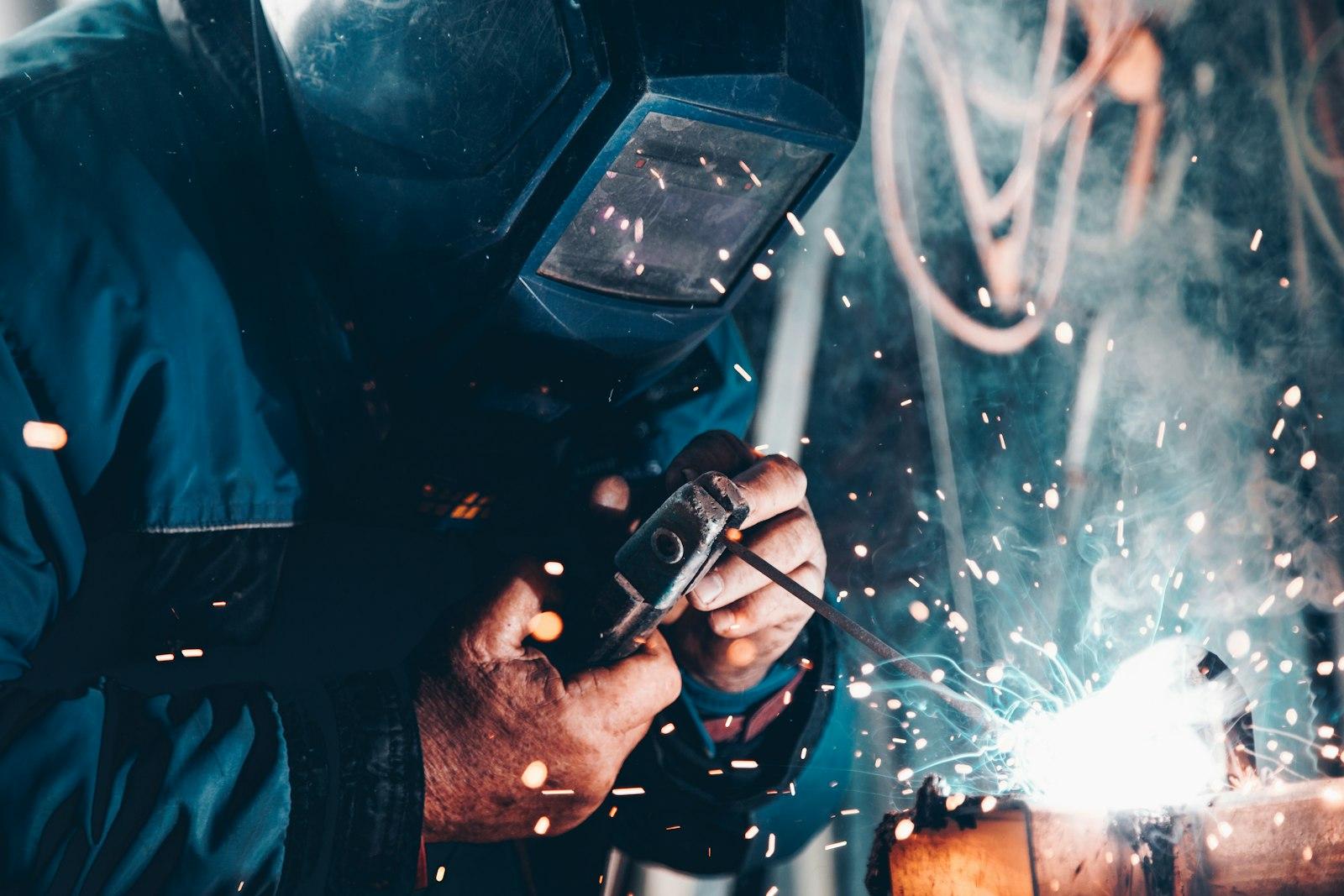 Welder at work with sparks flying from a steel joint